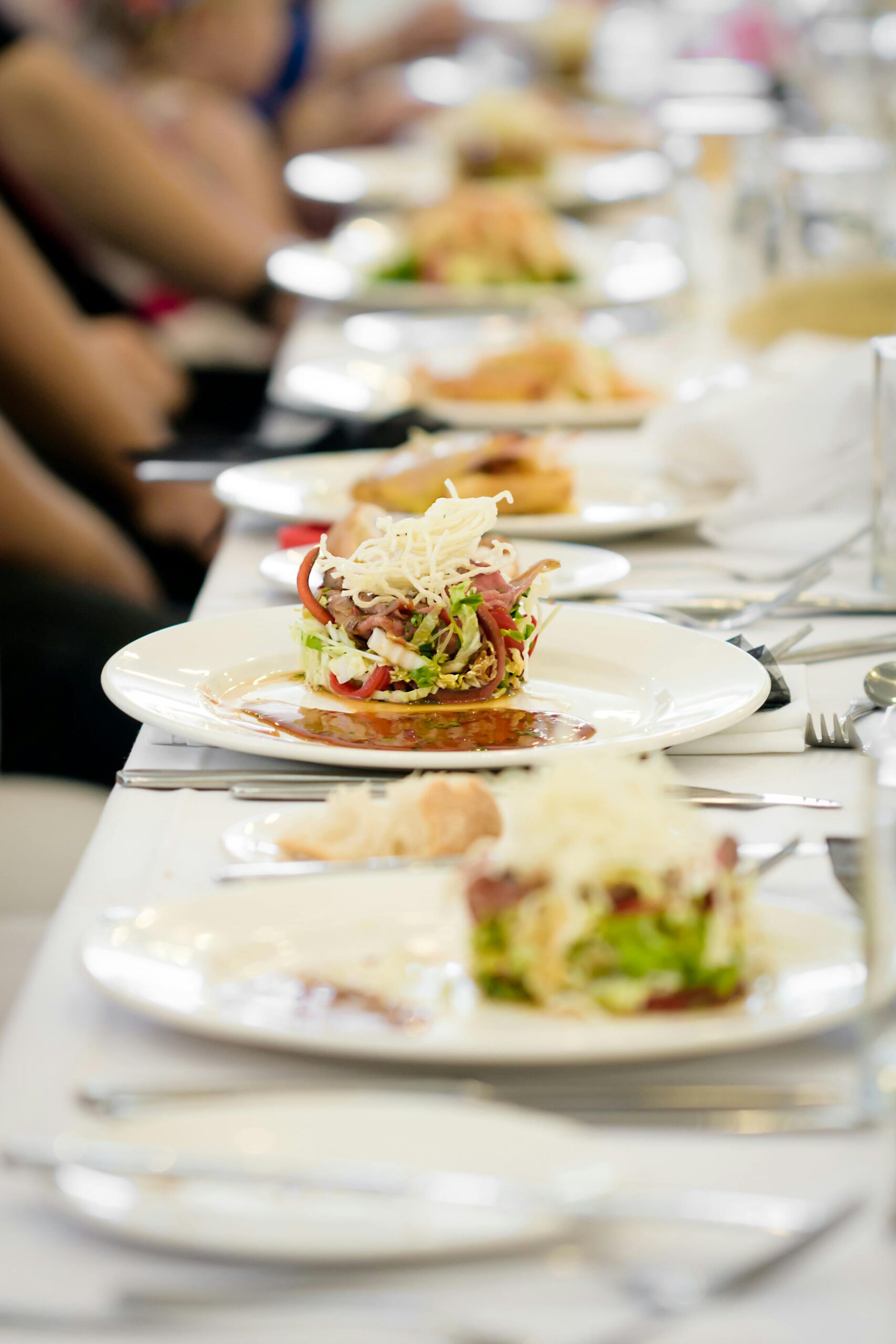 Long dining table set with gourmet salads, perfect for a fine dining experience.